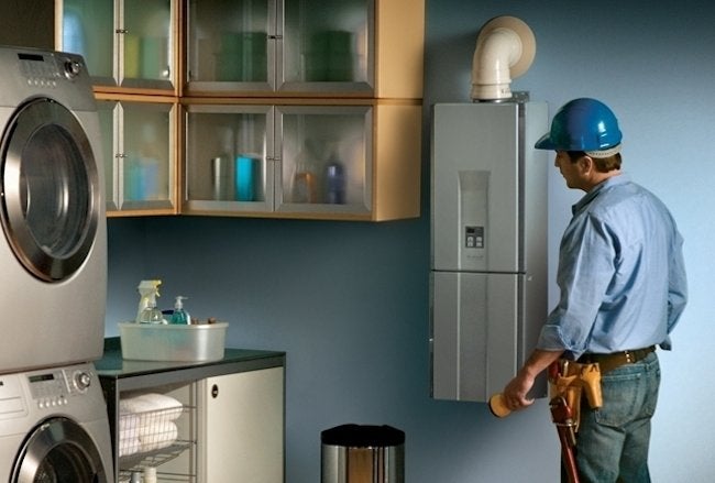 Man checking a tankless hot water system