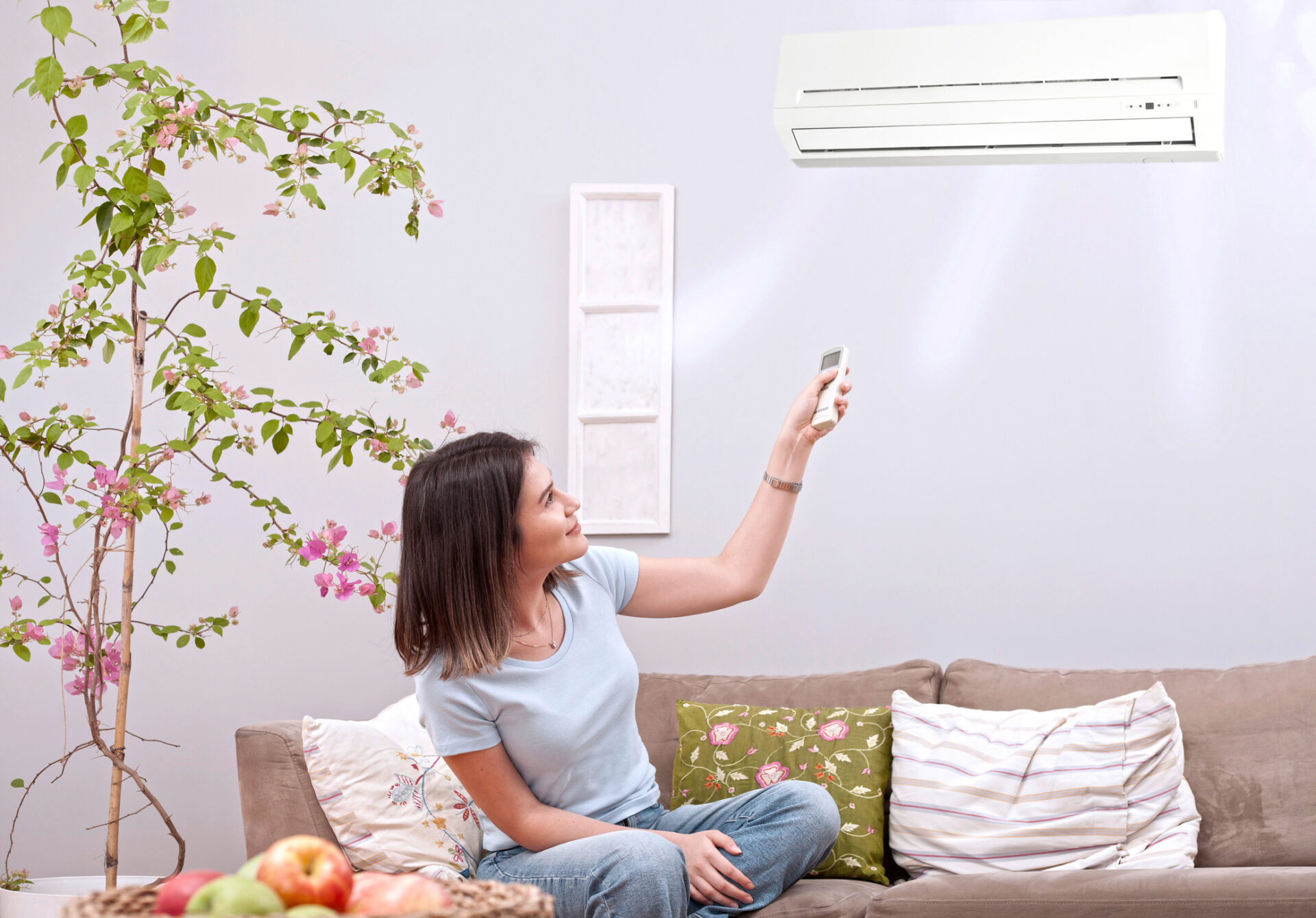 Ductless mini-split air conditioning unit mounted on a wall cooling a modern living room.