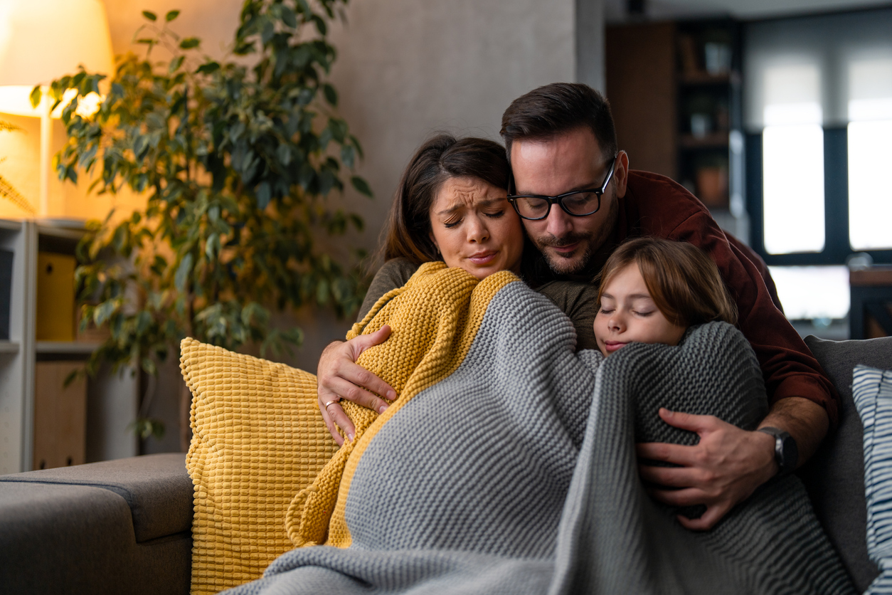 Family enjoying warmth under a cozy blanket near the home heating system.