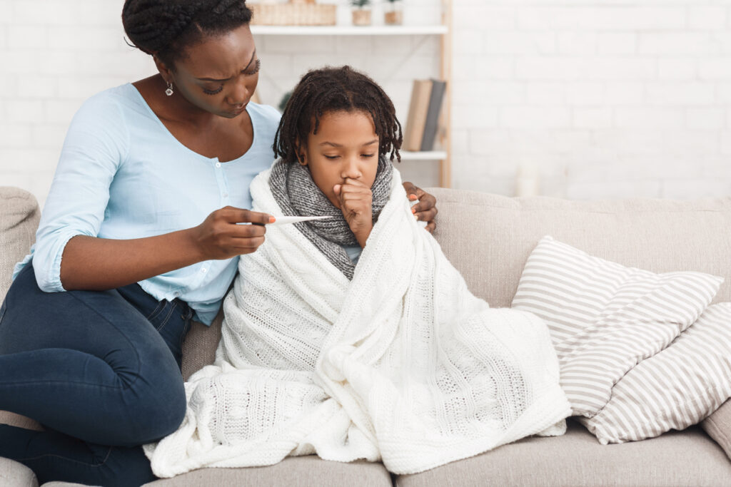 Woman checking cleaning supplies while disinfecting home to prevent cold and flu.