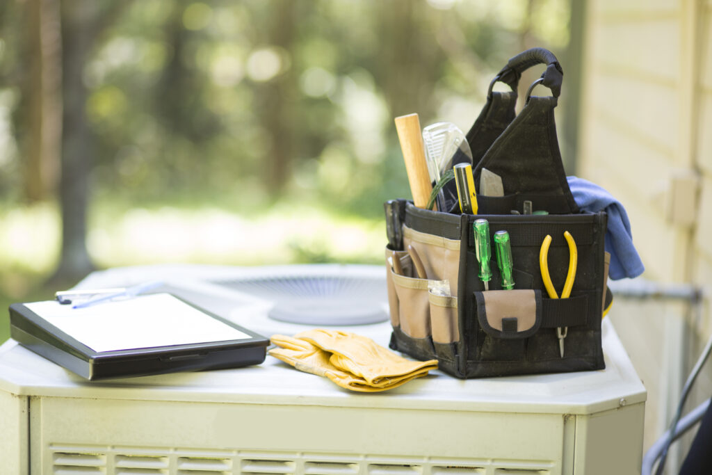 Technician using AC inspection tools to check air conditioner performance in hot weather.