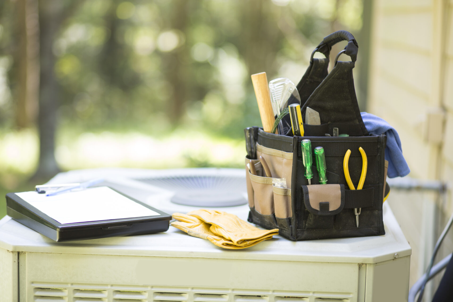 Technician using AC inspection tools to check air conditioner performance in hot weather.