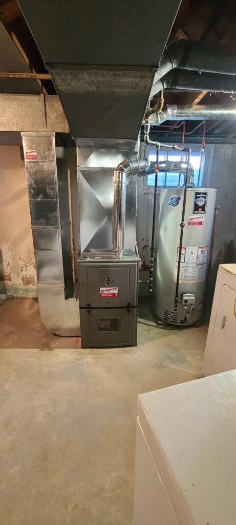 Furnace and water heater installed in a utility room.