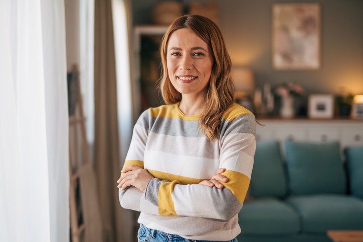 Happy woman standing in living room