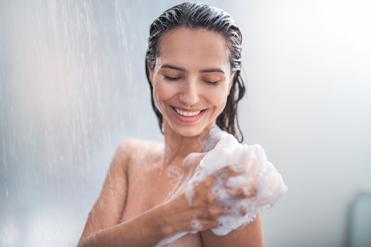 Girl taking a shower with consistent hot water from a well-maintained water heater