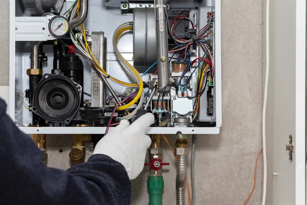 Technician repairing internal components of a combi boiler heating system