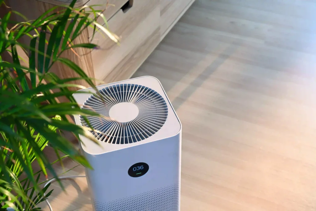 Modern home air cleaner and purifier unit next to an indoor plant